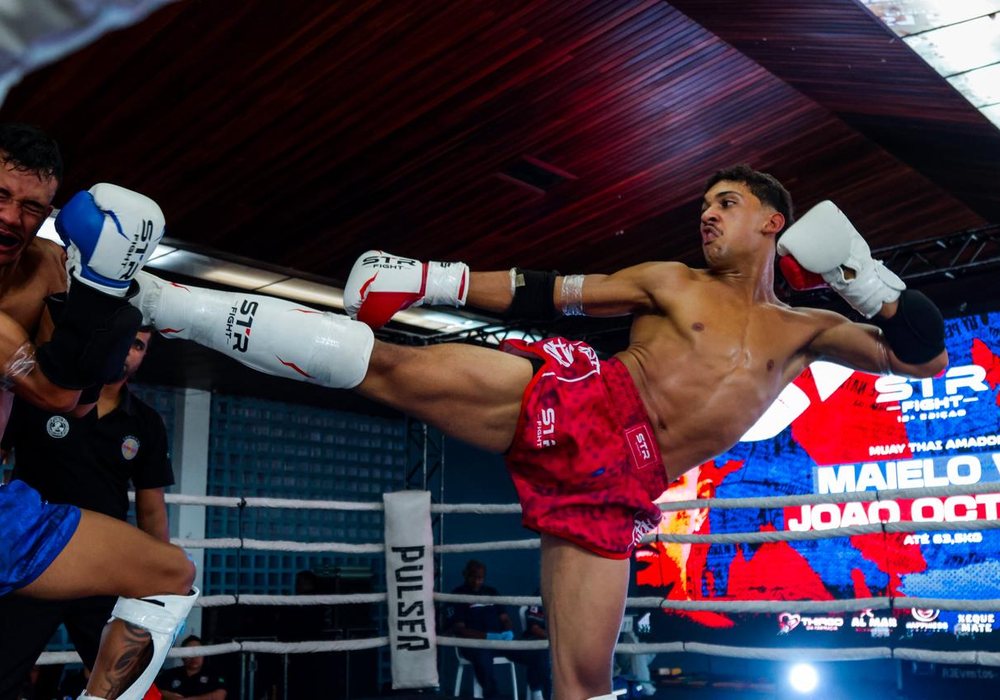 João Octávio aplicando um chute alto no adversário durante luta de muay thai no S1R Fight.
